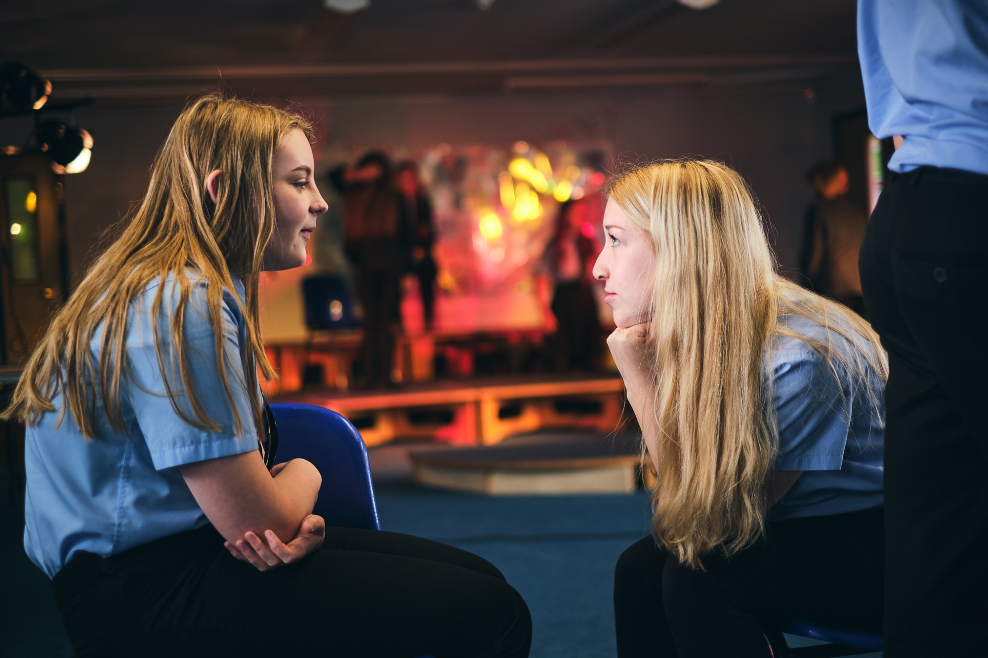 two students in a drama classroom looking at each other