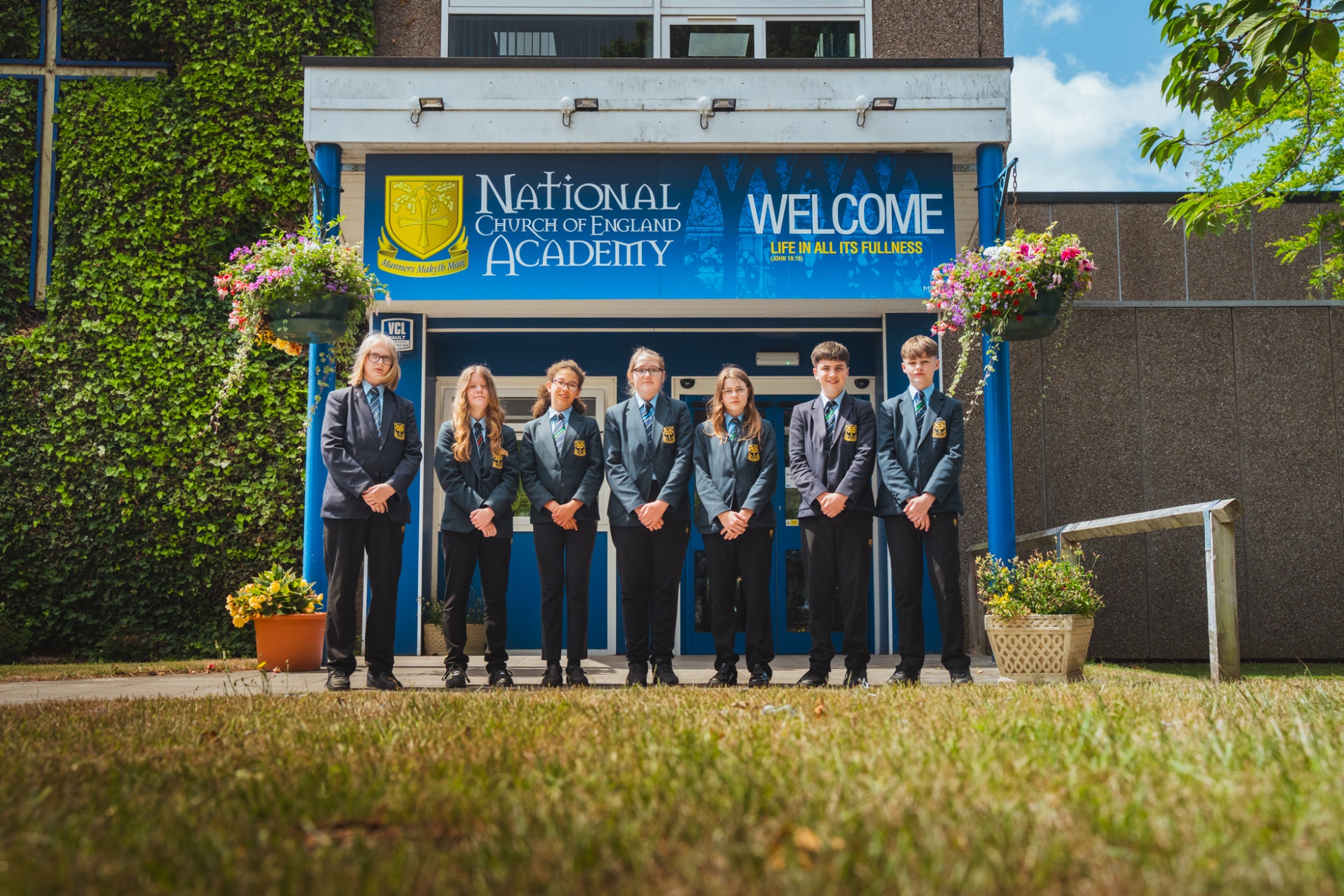 students outside school main entrance on sunny day